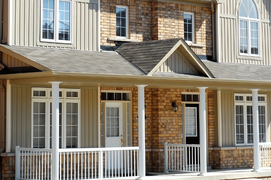 newly constructed duplex with black and white front doors and front porch